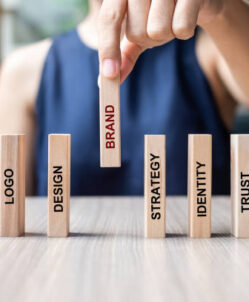 df Businesswoman hand placing or pulling wooden Dominoes with BRAND text. and Marketing, Advertising, Logo, Design, Strategy, Identity, Trust and Values. Product development concept